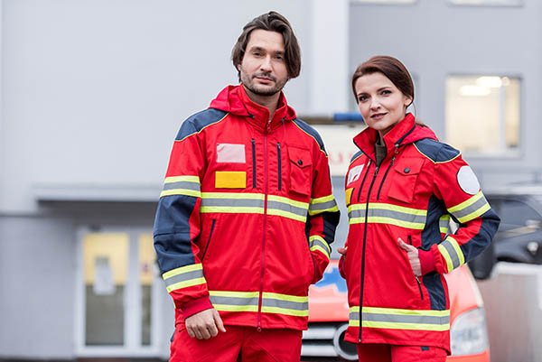 Paramedics in red uniform standing on street and looking at came